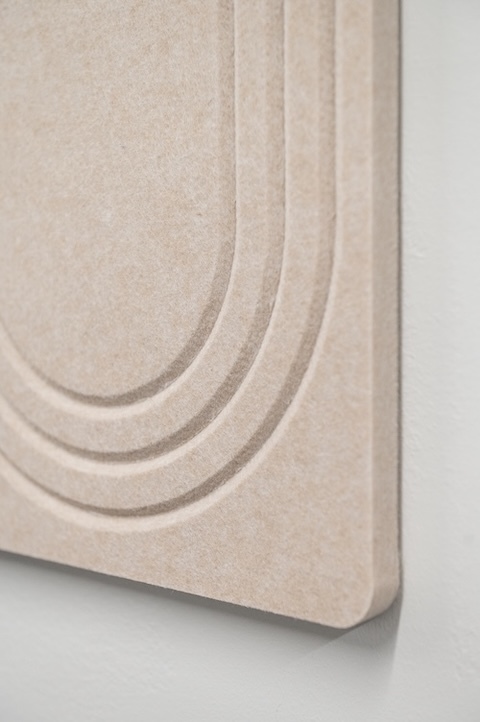 Close-up of a beige SoundSorb acoustic wall tile featuring a layered arch pattern with a textured surface and rounded corners.