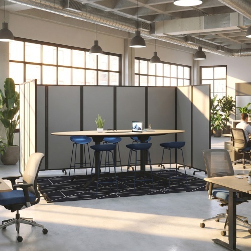 Overhead view of a small meeting room formed by blue modular partitions, with a white table, brown chairs, and a potted plant.